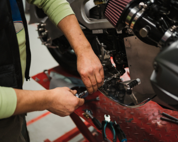 Man fixing a motorcycle in a modern workshop