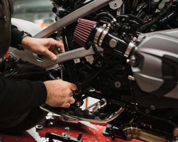 Man fixing a motorcycle in a modern workshop